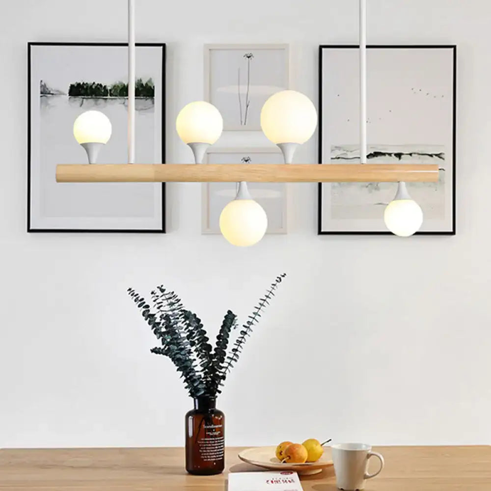 Modern wood island lamp with five warm white globe lights and natural wood bar for dining room bulb base fixture