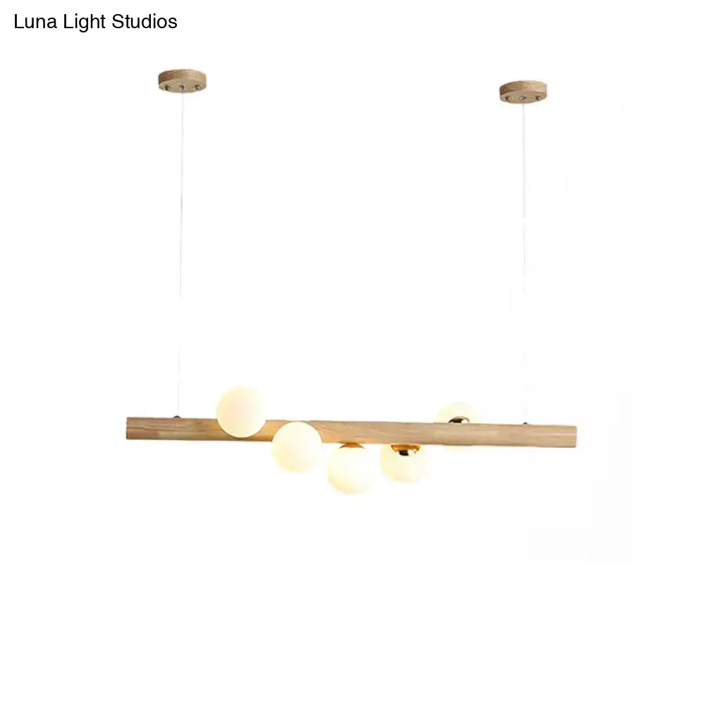 Modern minimalist ceiling light DecorBites wood island fixture with natural wood bar and frosted opal glass globes