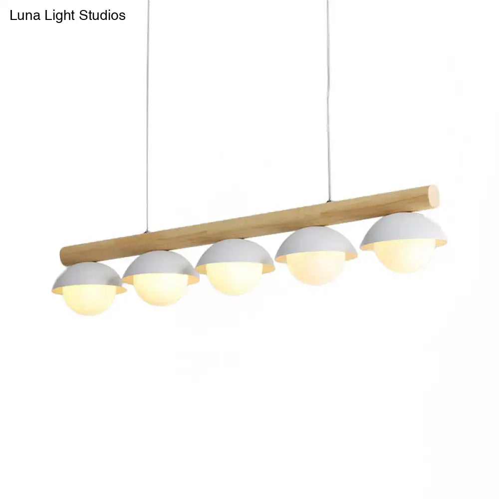 Modern pendant linear chandelier with natural wood stem and five matte gray dome white shades emitting warm light