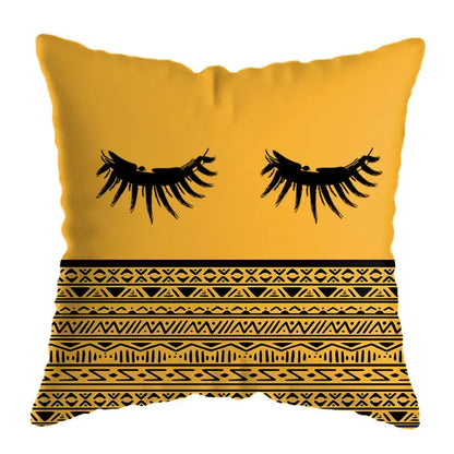 A square yellow throw pillow with black graphic eyelashes and geometric patterns for modern geometric deer print decor