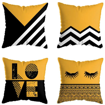 Set of four square throw pillows with bold yellow and black geometric deer print designs for living room decor