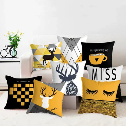 A collection of modern yellow and black geometric deer print decorative throw pillowcases arranged on a sofa