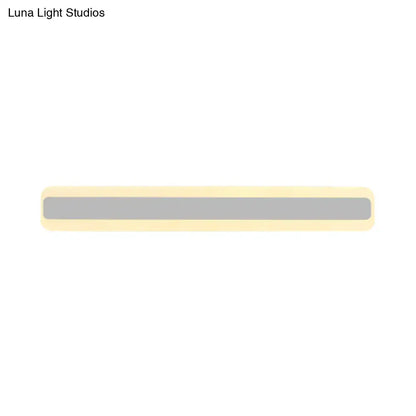 A sleek minimalist bathroom vanity light strip with matte gray center and cream rounded edges emitting white light