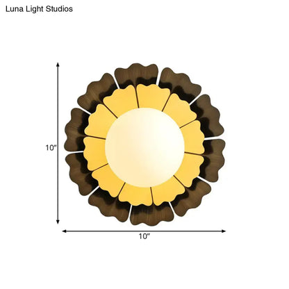 Modern yellow and brown sunflower wall sconce with layered glass petals and a central illuminated circle for bedroom lighting