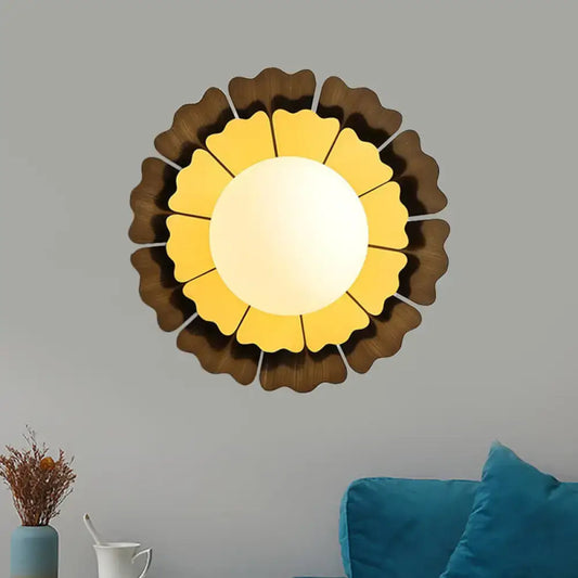 Modern yellow and brown sunflower wall sconce with warm yellow glass center and dark brown wooden arms for bedroom lighting