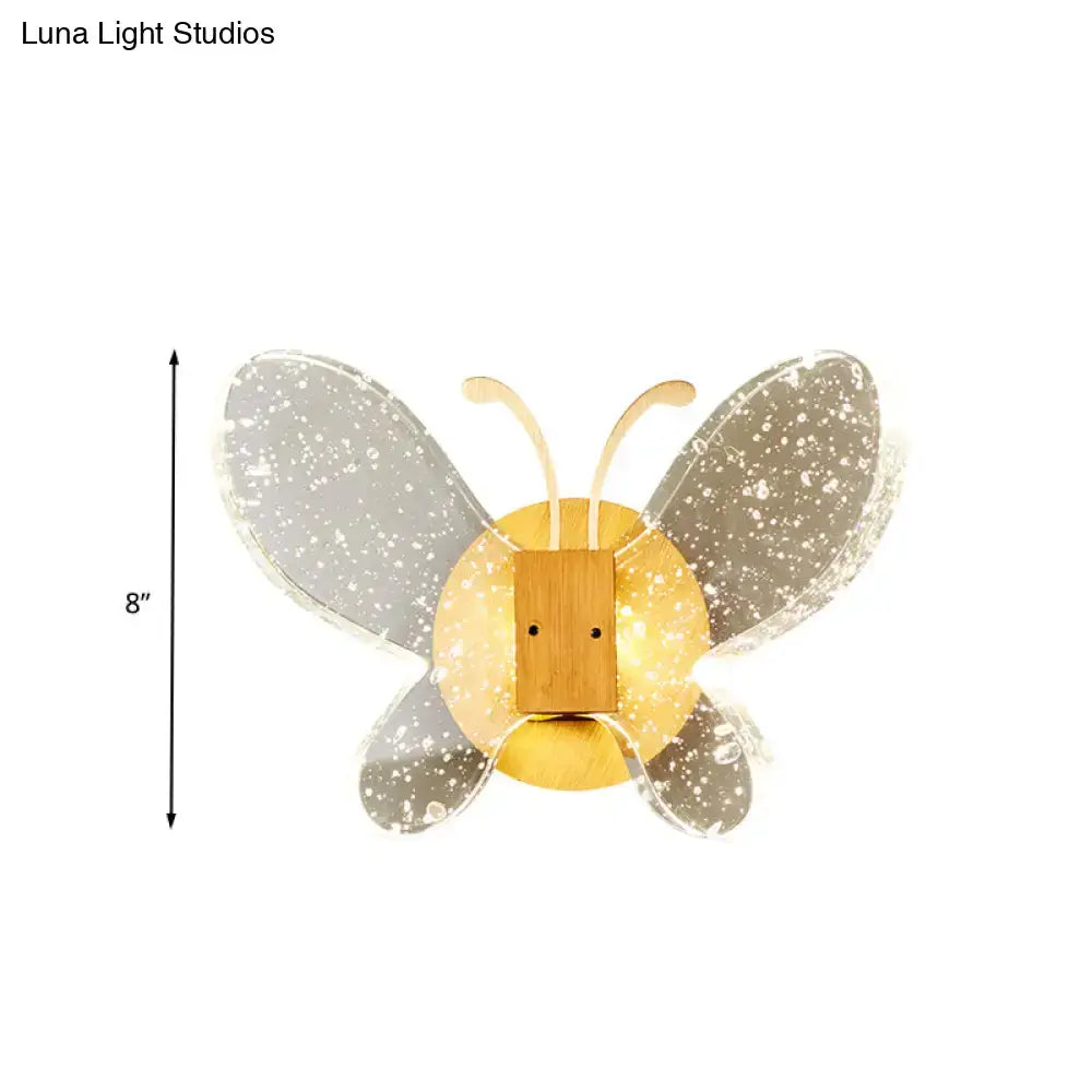 A modern yellow and clear butterfly bubble crystal sconce with translucent speckled wings and a warm golden bamboo face