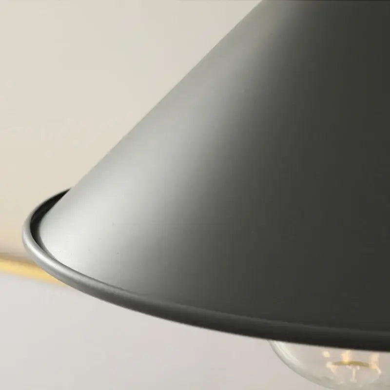 Matte black conical pendant light with smooth curved rim featuring decorbites copper knob iron for kitchens