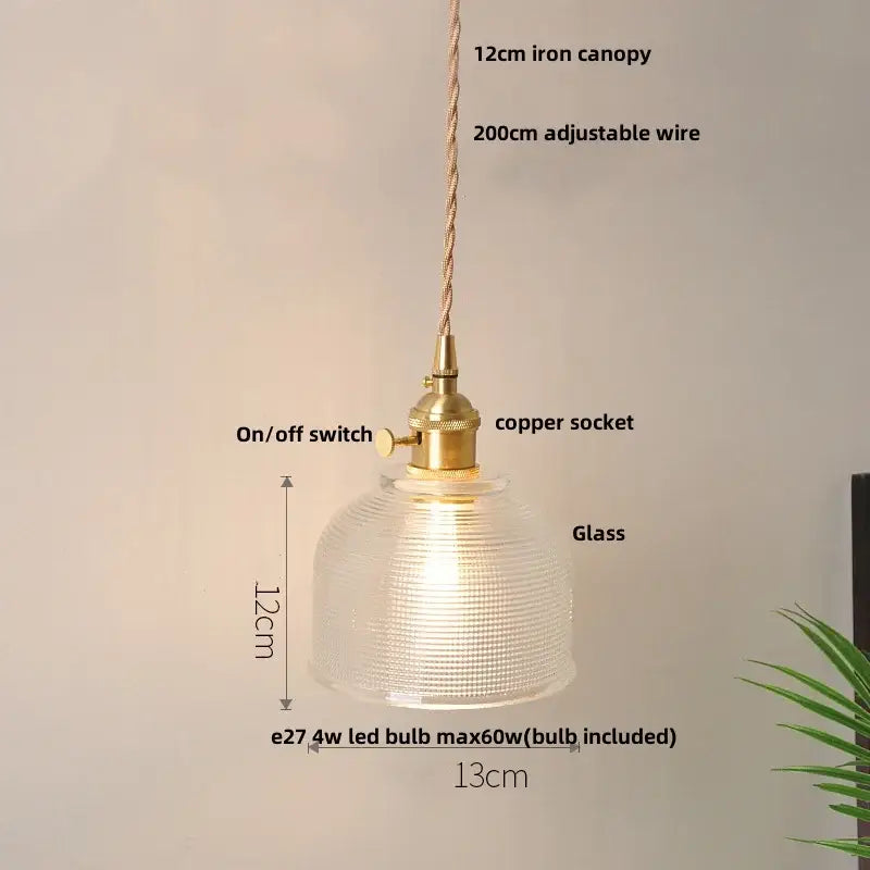 A modern yellow conical pendant light with a warm-glowing glass dome and decorbites copper knob iron hardware for kitchens
