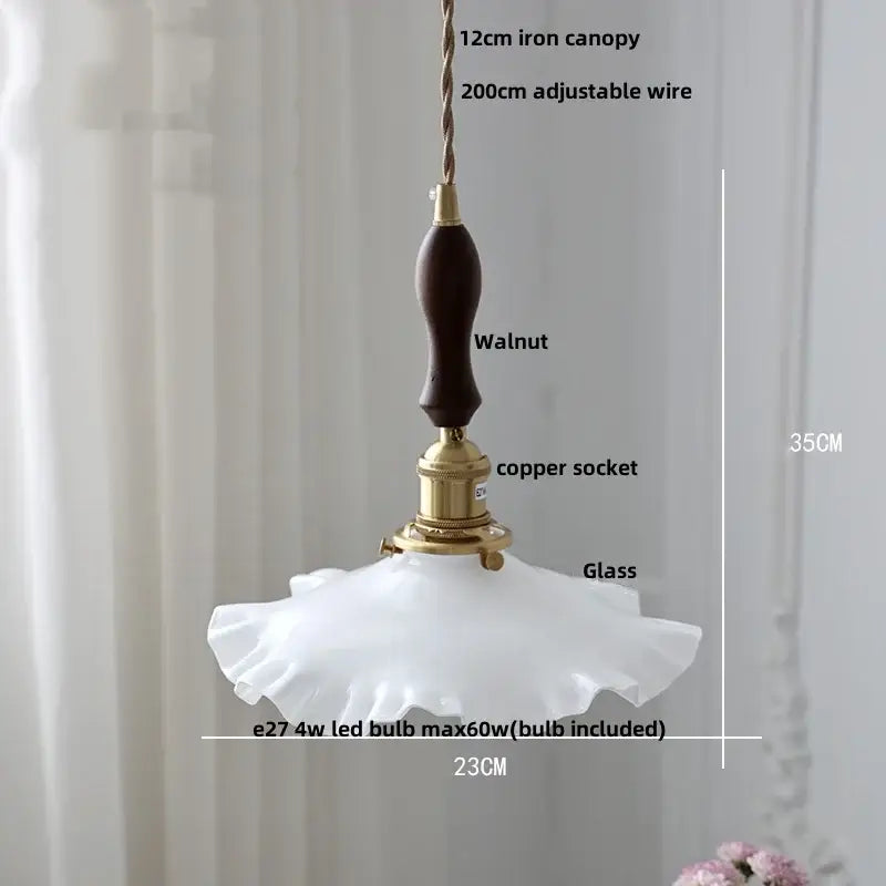 A delicate white glass pendant light with ruffled edge and dark walnut handle featuring decorbites copper knob