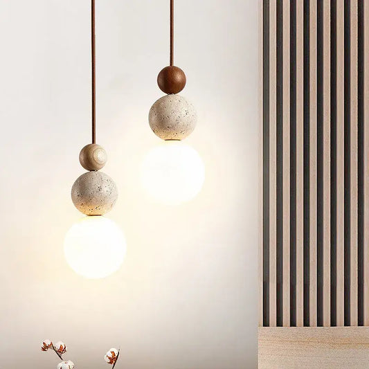 Modern yellow travertine and wood led bulb pendant light with stacked concrete spheres and warm glow for kitchen use