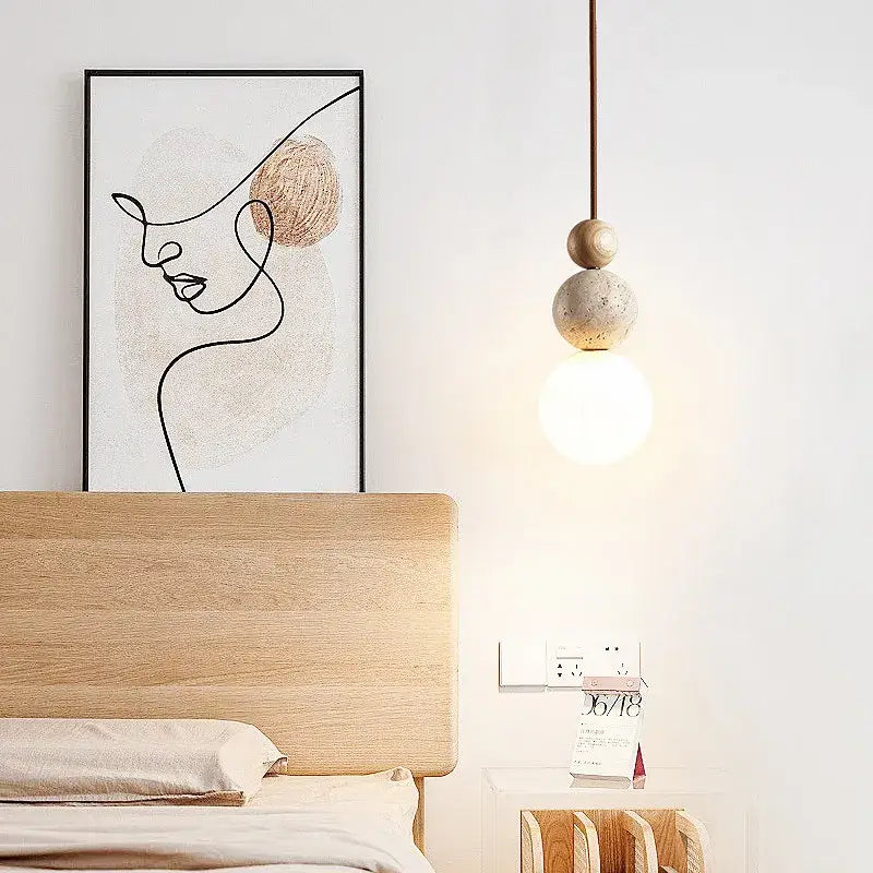 Modern yellow travertine and wood cord pendant light with two wooden spheres and glowing led bulb for kitchen use