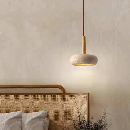 Modern yellow travertine stone pendant light with a round speckled concrete shade and wooden stem for kitchen island
