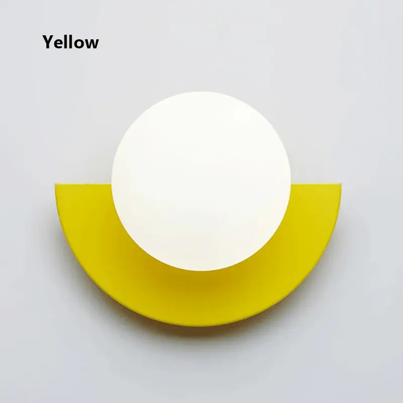 Modern yellow and white kids macaron led wall lamp with smooth spherical head mounted on vibrant yellow base by decorbites