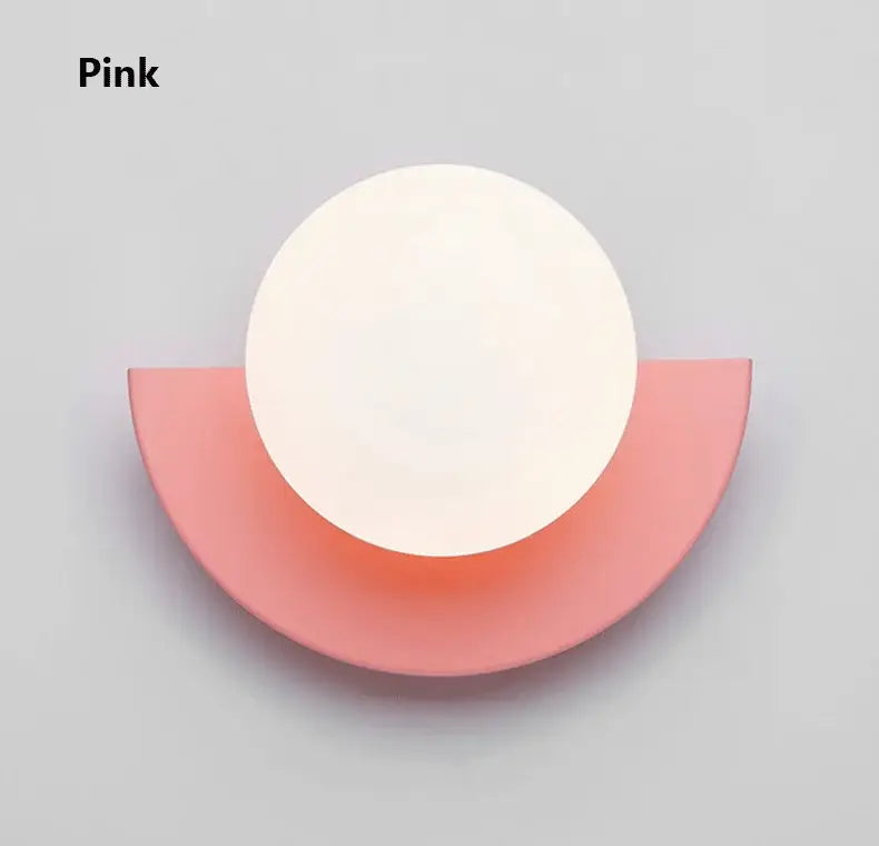 Pink minimalist wall lamp with smooth matte circular top and curved base from decorbites kids macaron led series