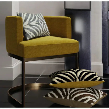 Mustard yellow velvet armchair with sleek black metal frame and zebra pattern pillow cover decorbites gold zebra design