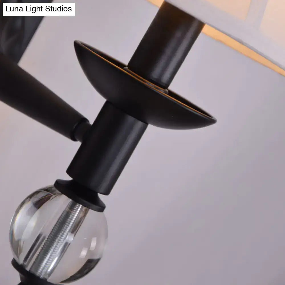 Modernist bell wall light featuring a black metal arm with a clear crystal globe base for bedroom sconce lighting