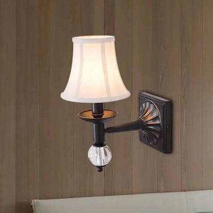 A classic black wrought iron modernist bell wall light with white fabric shade and clear crystal globe accent for bedroom