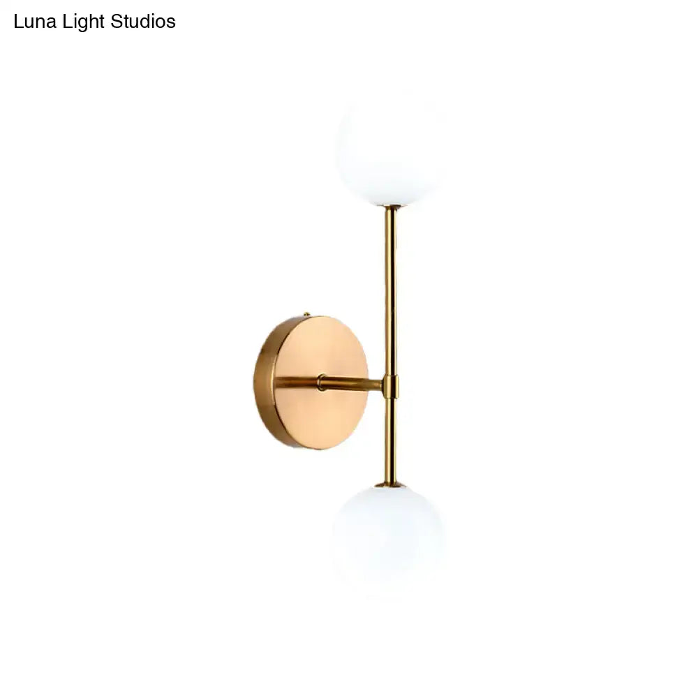 Modernist black gold wall sconce with gold finish and two frosted glass globe shades for living room lighting