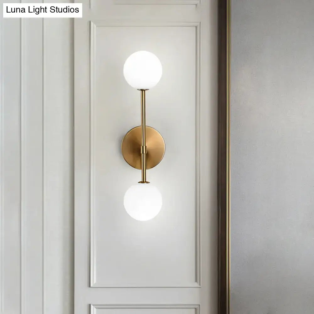 Modernist black gold wall sconce with brass finish and two frosted glass globe shades for living room lighting