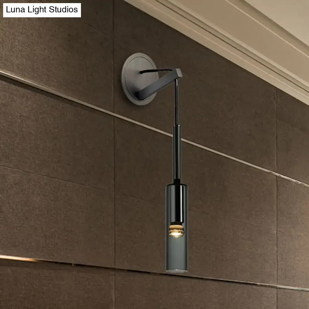 Modernist black led crystal tube wall sconce with a sleek metallic arm and circular base for bedroom lighting