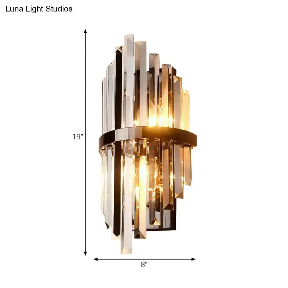 Modernist wall lamp with clear and amber crystal prism rods framed by a sleek brass band for bedroom use