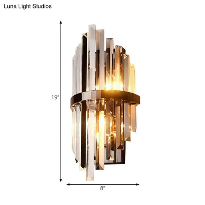 Modernist wall lamp with clear and amber crystal prism rods framed by a sleek brass band for bedroom use