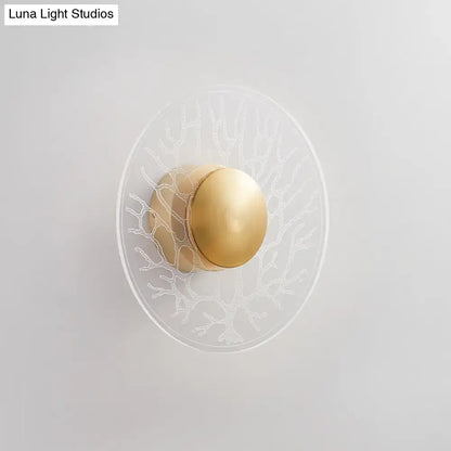 Modernist brass light fixture with clear glass oval base and polished gold spherical bulb featuring white etched coral design