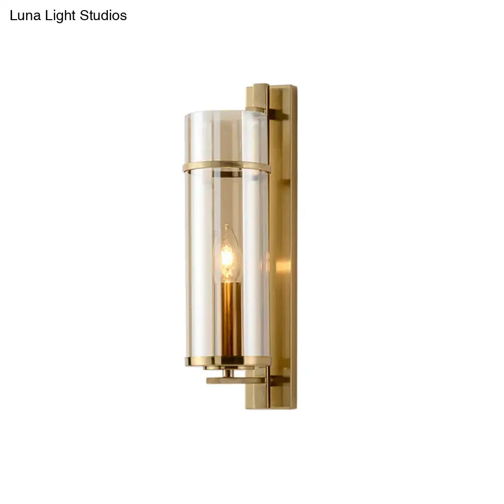 Modernist brass wall lamp with clear cylindrical glass and exposed filament bulb for bedroom sconce light fixture