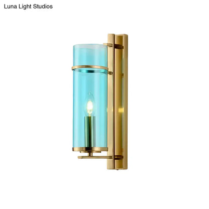 Modernist brass bedroom sconce light with water blue glass cylinder and warm bulb as elegant wall lamp fixture