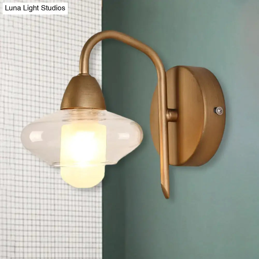 Antique brass-finished wall lamp with a clear glass teardrop shade and bulb base for modernist bedroom sconce lighting