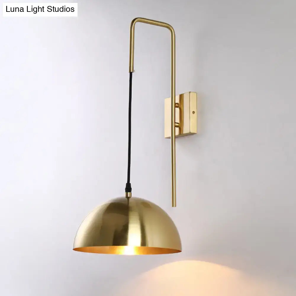 Gold-toned brass modernist dome sconce wall light with sleek curved arm and dome-shaped shade for bedroom use