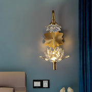 Modernist brass finish wall sconce with gold-toned crystal shade lotus flower design and central illuminated bloom