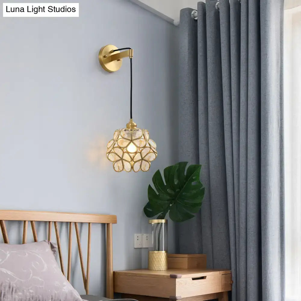 Gold-toned modernist brass bulb bedside sconce with light pink clear delicate petal-like glass shade