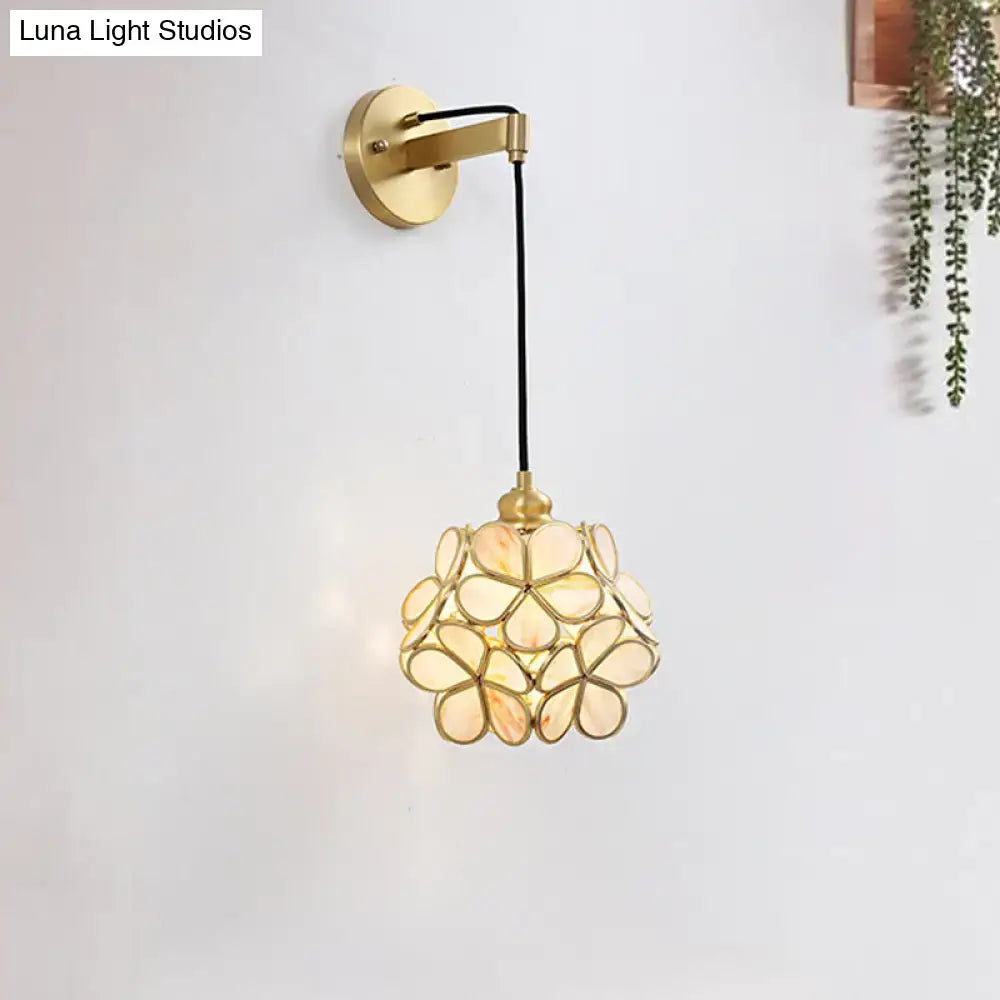 Modernist brass floral glass bulb bedside sconce with light pink and cream flower-shaped shade in gold tone
