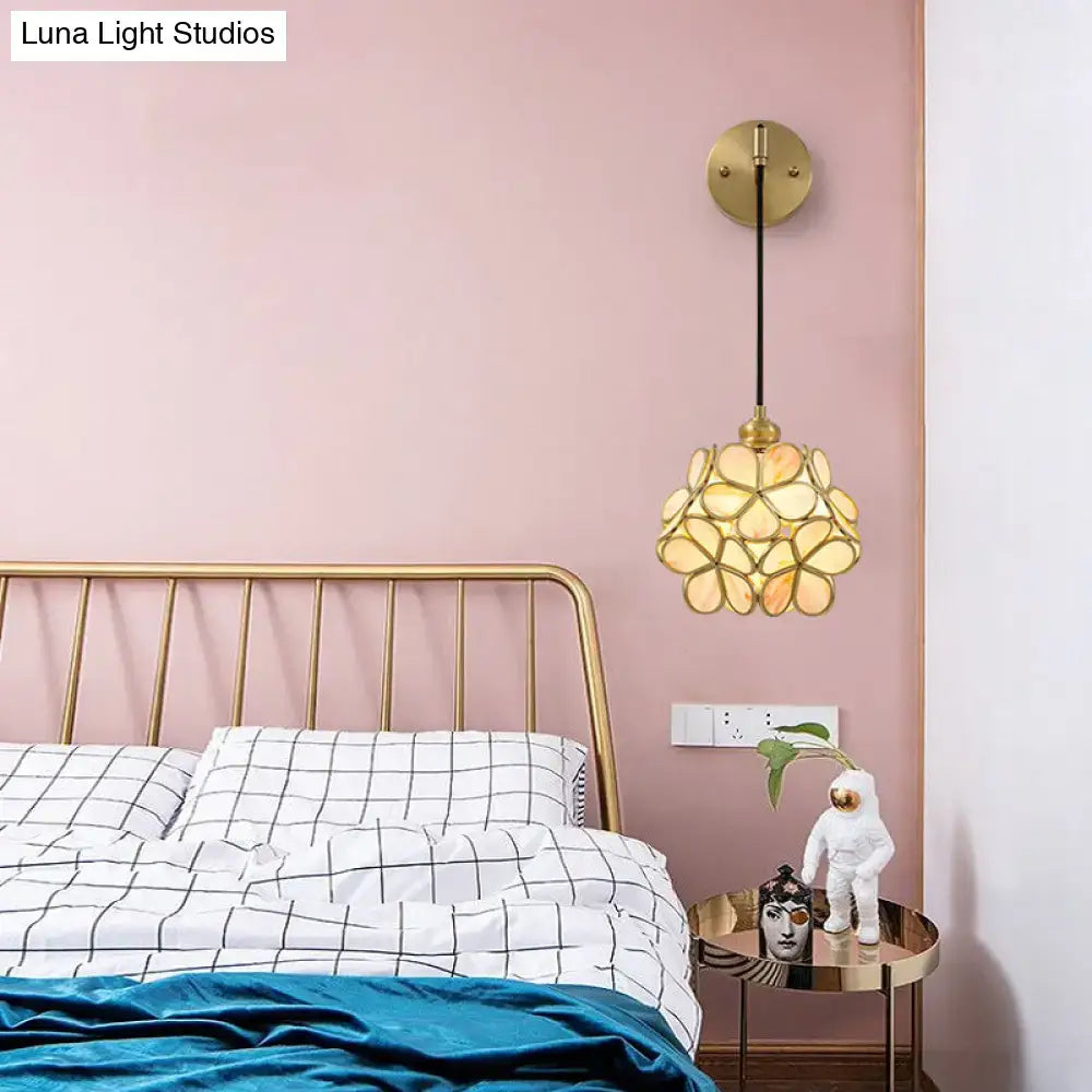 Modernist brass bulb bedside sconce with gold-toned floral mosaic light pink and clear amber glass shade