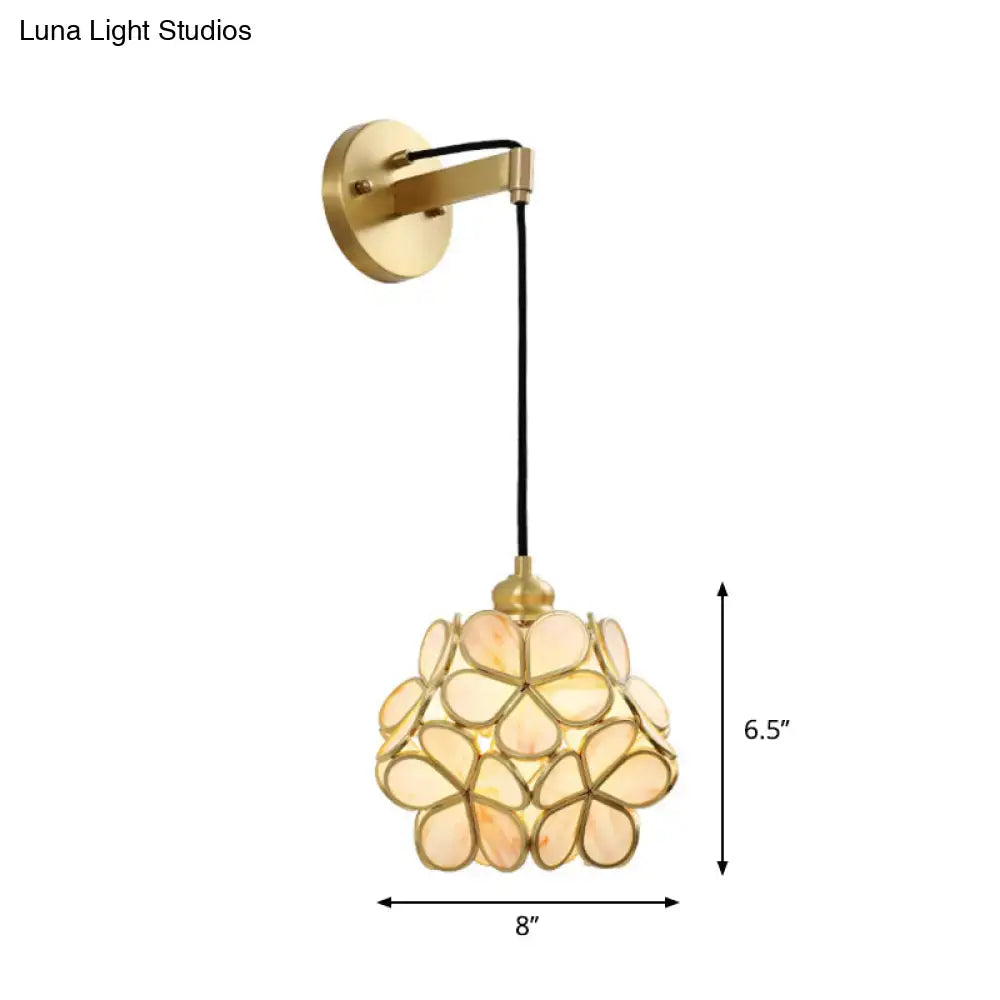 Modernist brass floral bulb bedside sconce with a translucent peach shell shade in light pink and clear tones