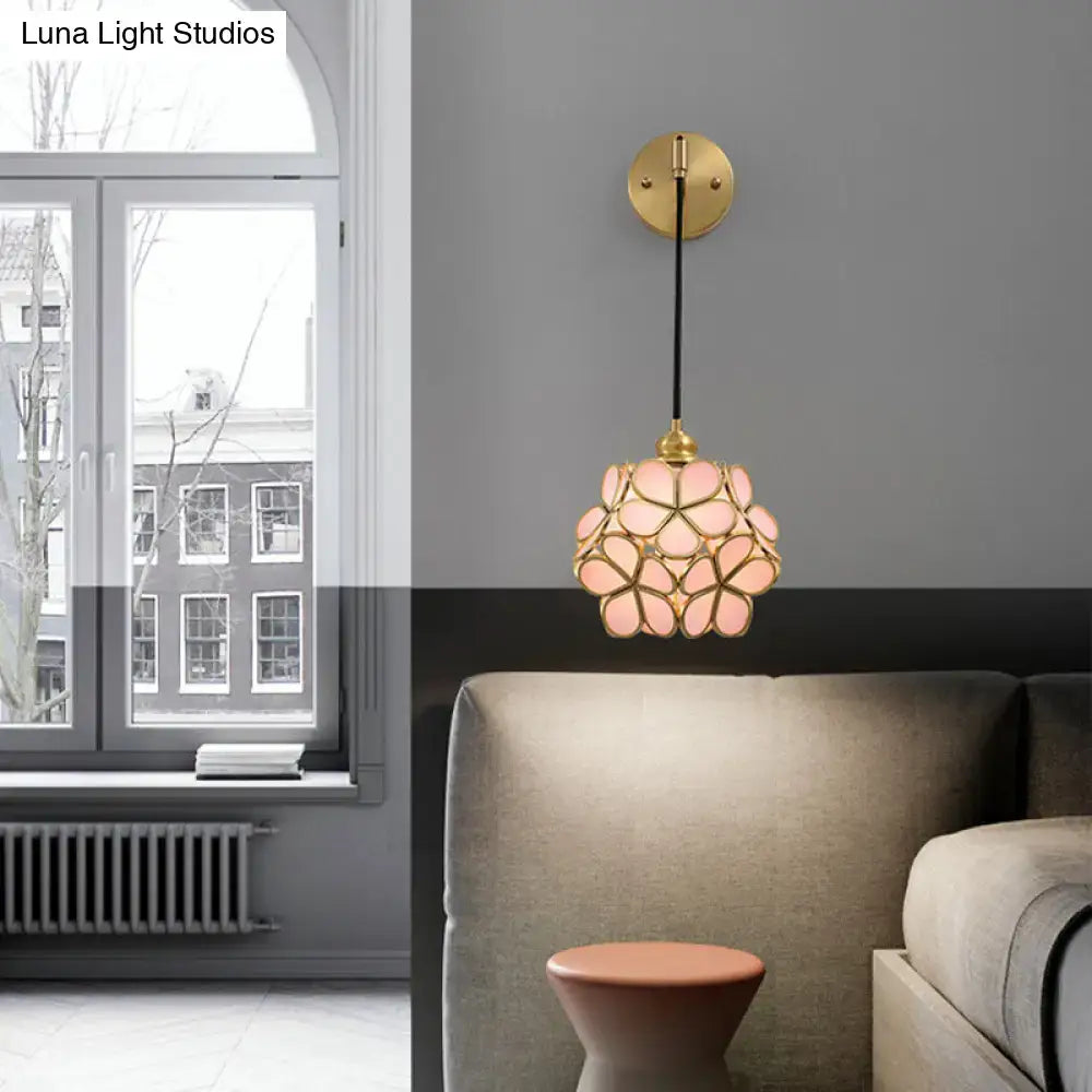 Modernist brass floral glass bulb bedside sconce with light pink and clear petals and gold-toned frame and chain
