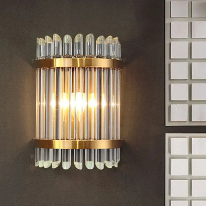 Modernist clear crystal wall sconce with gold finish and vertical glass tubes for elegant living room lighting