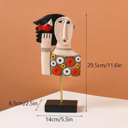 Stylized ceramic abstract people statue figure with black hair red fish accessory and circular pattern on gold stand decorbites abstract people