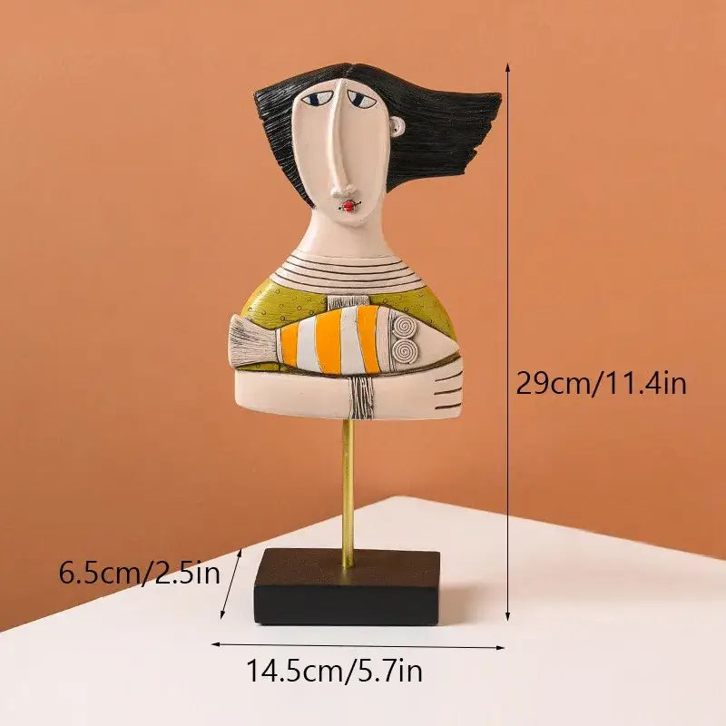 Stylized ceramic abstract people statue figure with black hair, green and white top, holding orange-and-white fish for living room decorbites abstract people