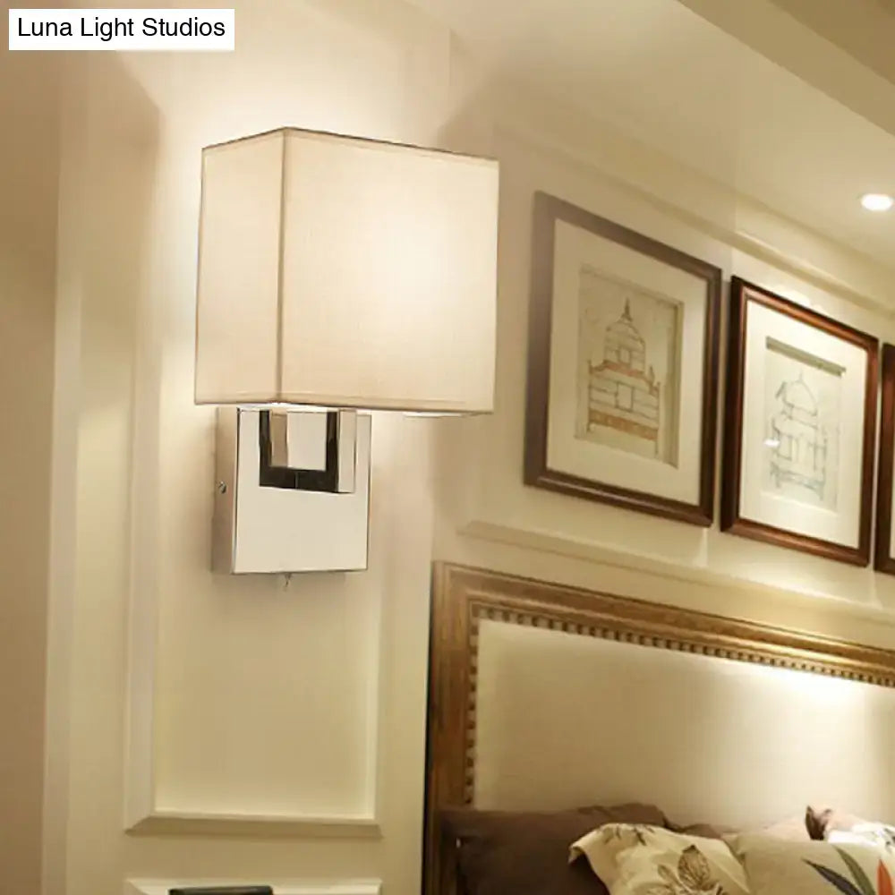 Modernist gold and beige sconce light fixture with white fabric shade and chrome base for bedroom wall lighting