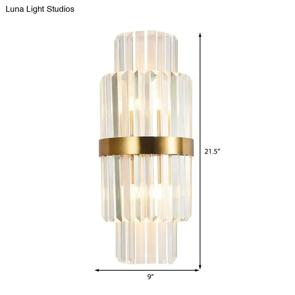 A modernist gold and clear crystal cylinder wall lighting fixture with stacked faceted rods for living room use