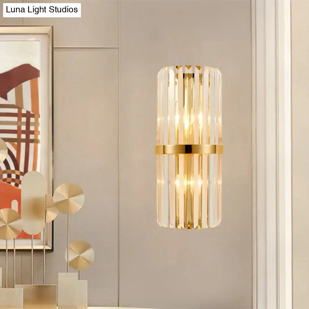 Modernist gold cylinder wall lighting fixture with vertical clear crystal rods and central brass band for living room use