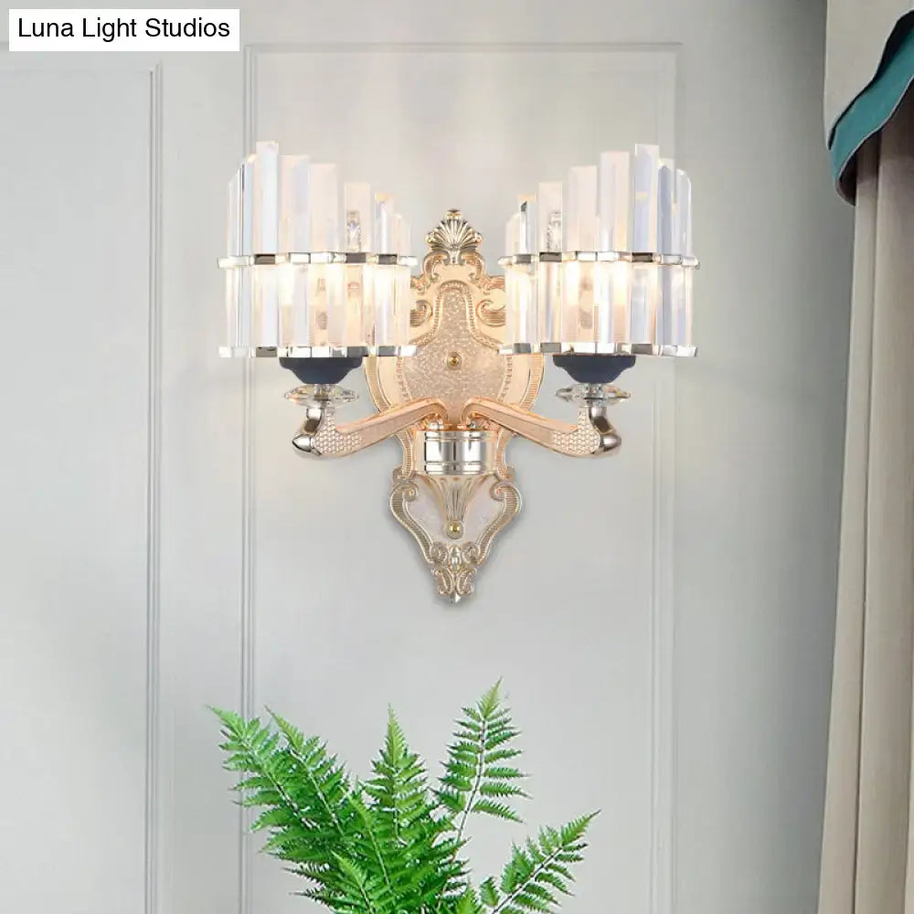 Modernist gold wall light with ornate metalwork and vertical crystal bars featuring a conical shade for living room