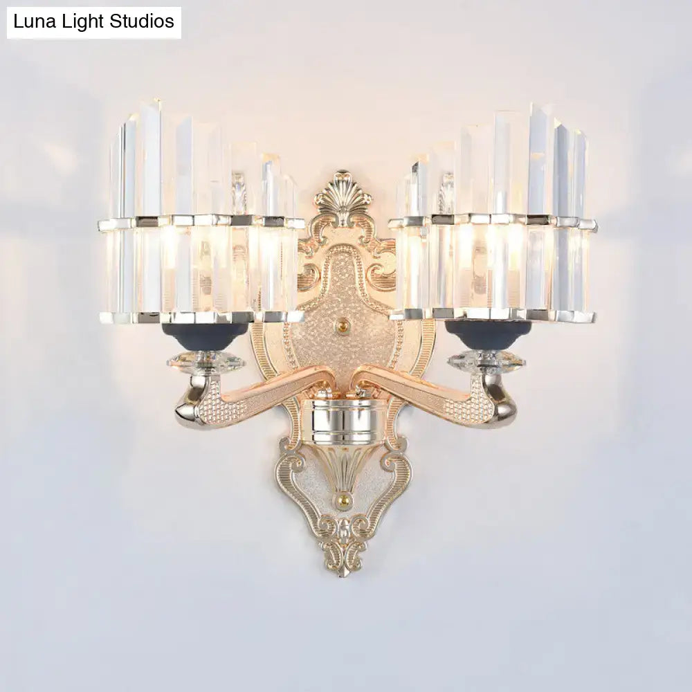 Gold-toned ornate wall light with conical crystal shades and decorative metal arms for living room use