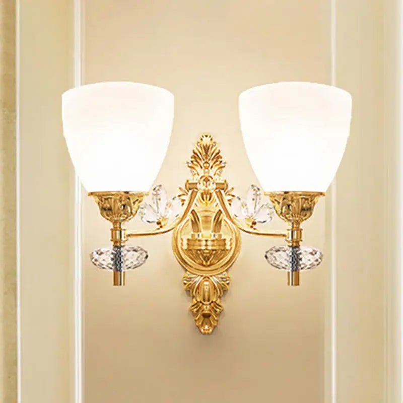 Modernist gold finish crystal wall light with ornate design, two frosted glass shades, and bulb base for bedroom use