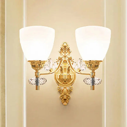 Modernist gold finish crystal wall light with ornate design, two frosted glass shades, and bulb base for bedroom use