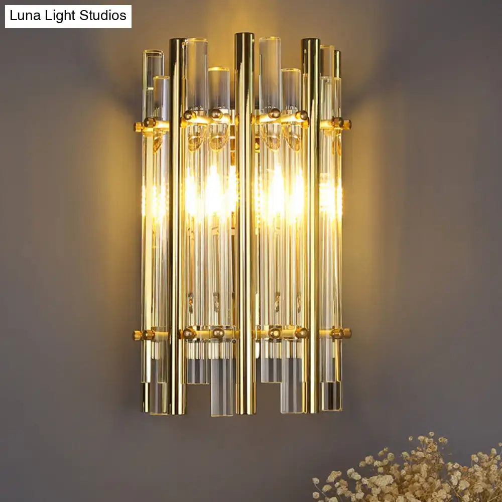 Modernist gold tubular wall sconce with vertical glass tubes and brass accents for bedroom lighting