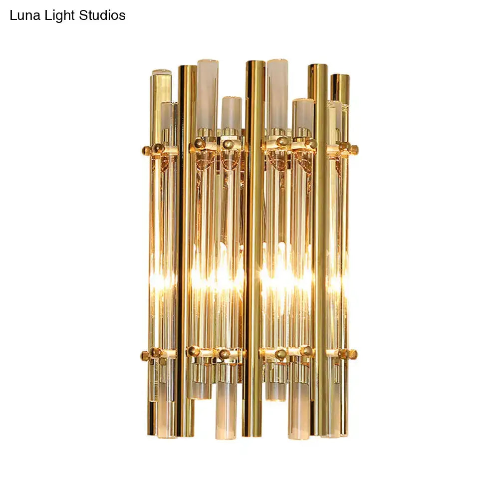 Modernist gold tubular wall sconce featuring vertical glass tubes and frosted accents for bedroom lighting