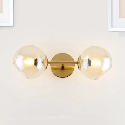 Modernist gold wall lamp with two frosted glass shades for living room featuring a gold-toned wall sconce design